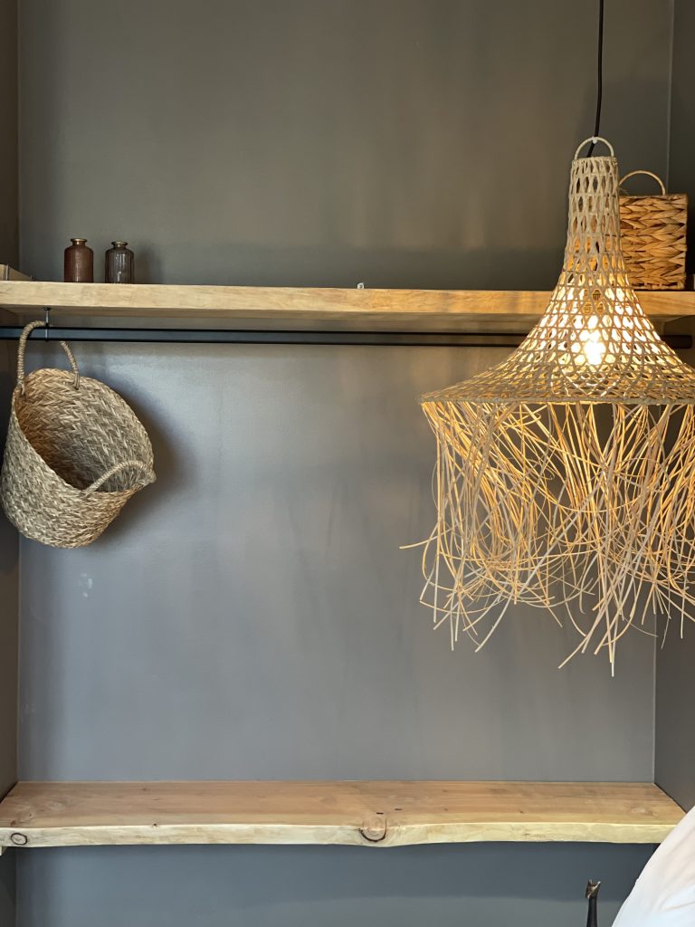 Aménagement de dressing ouvert dans une chambre, alliant fonctionnalité et esthétisme pour un espace harmonieux et épuré.