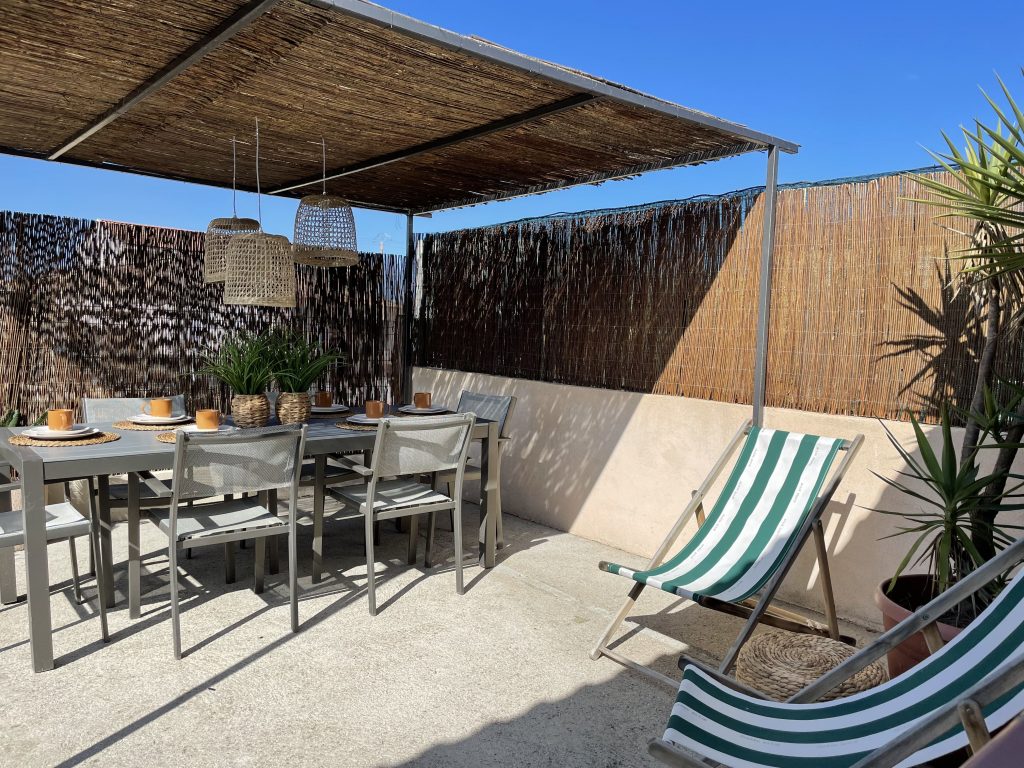Terrasse aménagée avec chilienne confortable pour la détente au soleil, intégrée au projet de home staging A Casa Cantone en Corse, location saisonnière chaleureuse et méditerranéenne.