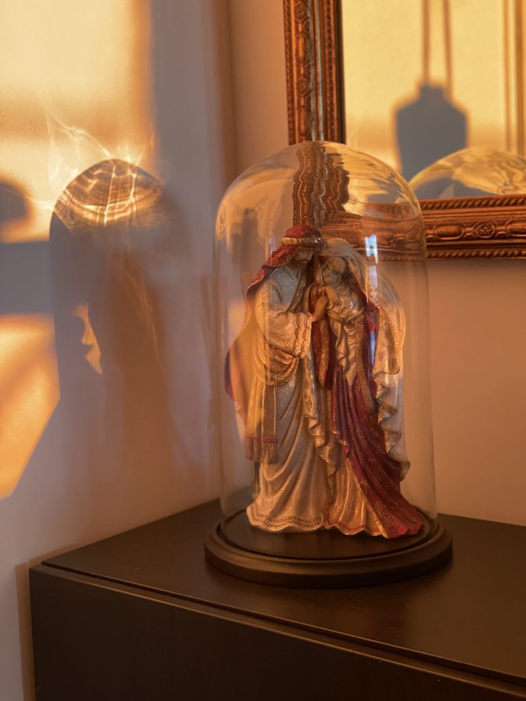 Statue sous cloche en verre et objets décoratifs, intégrés dans la rénovation méditerranéenne de la villa Pietrabugno.