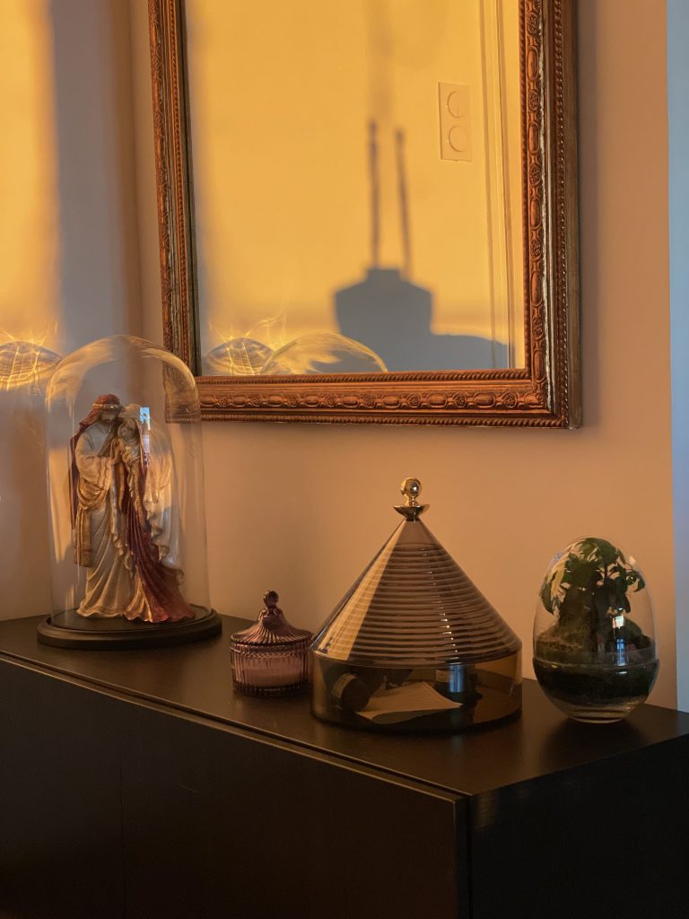 Meuble décoratif en bois foncé avec objets artisanaux et lumière tamisée, villa Pietrabugno Bastia.