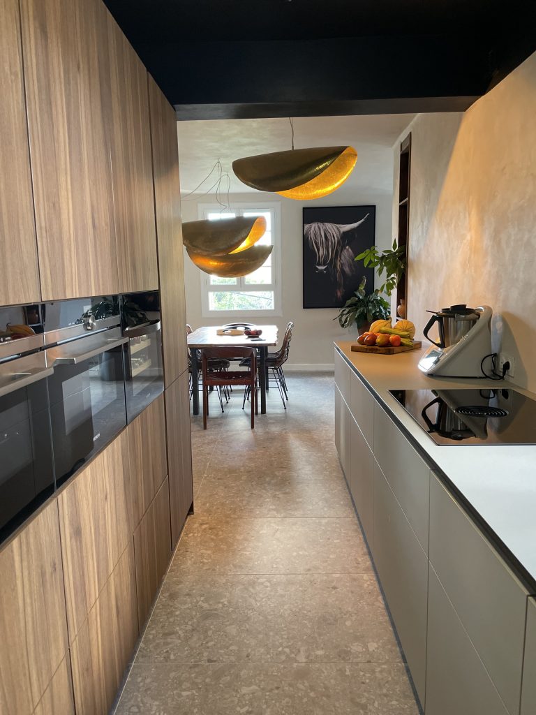 Cuisine contemporaine minimaliste sans poignées, avec éclairage doré et plan de travail en pierre, rooftop Bastia.