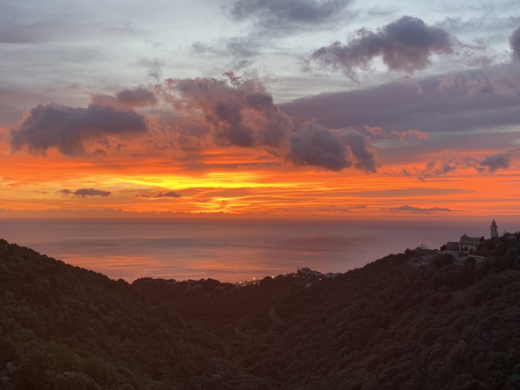 Vue depuis ka maison sur la vallée descendant jusqu'au port de Bastia, avec en perspective un lever de soleil illuminant l'île de Montécristo.