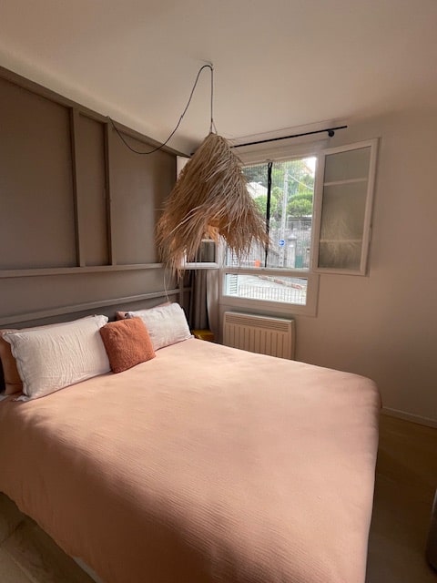 Chambre rénovée avec suspension artisanale, teintes naturelles et ambiance douce, projet rooftop Bastia.