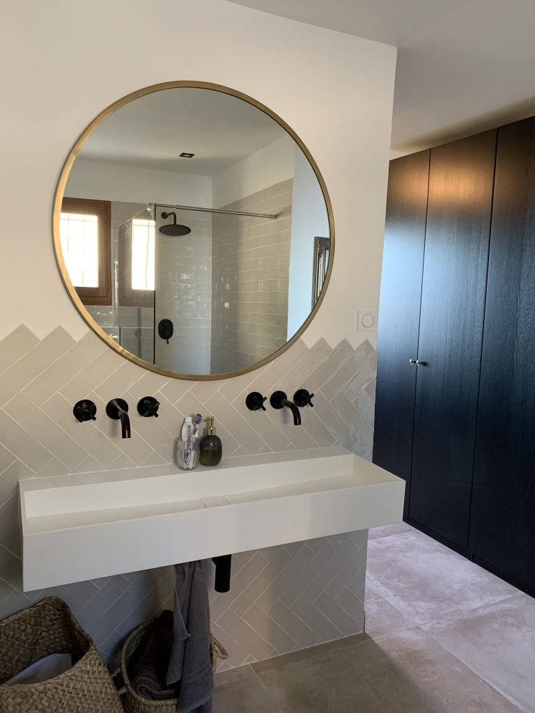 salle d'eau de la suite parental recouverte de bejmat beige mis en valeur par des détails noir et laiton, double vasque suspendu avec robinetteries encastrable.