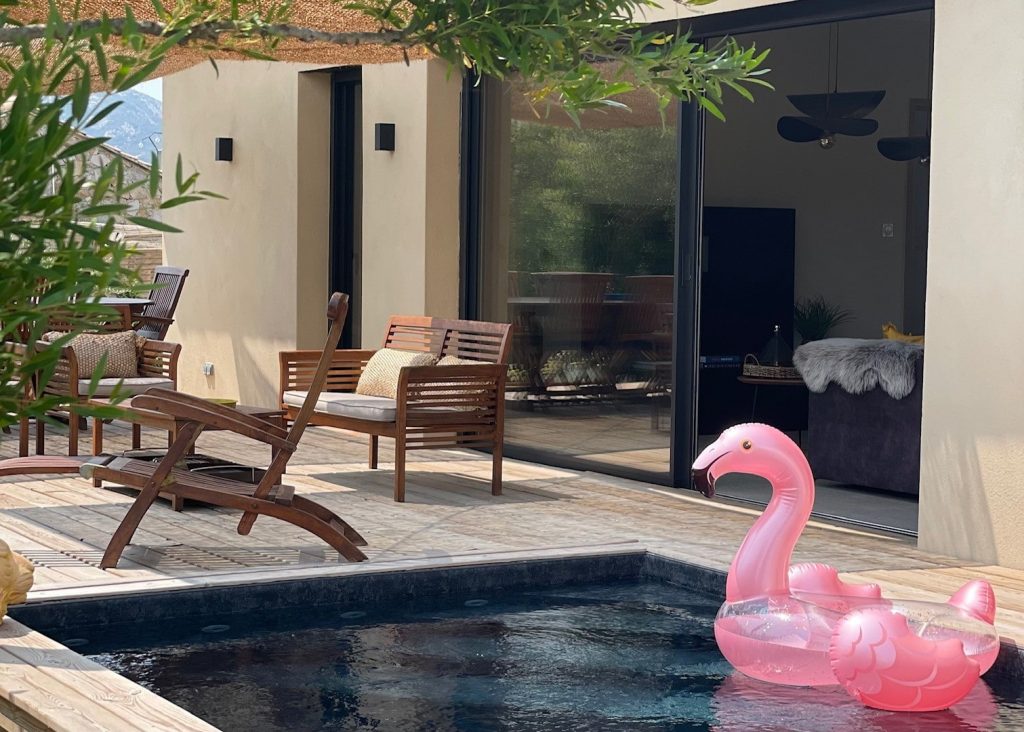 Piscine en béton recouverte d'une membrane armée couleur rivière au bord d'une terrasse ombragée