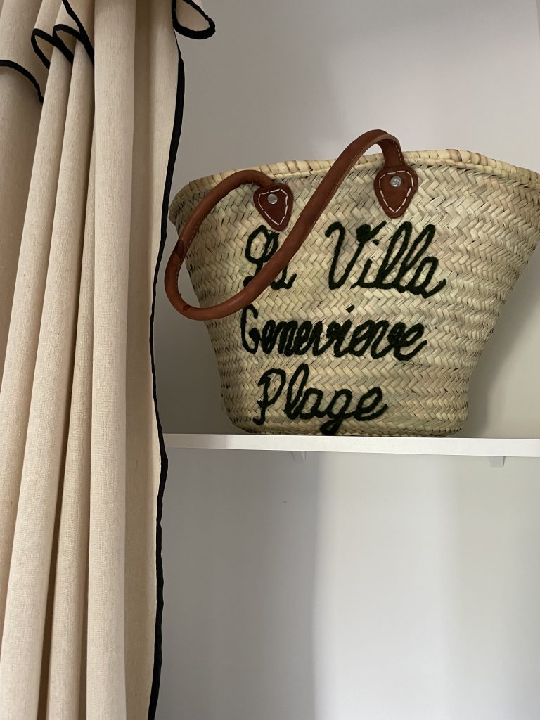 Panier tressé en matière naturelle personnalisé pour les locataires du projet La Villa Geneviève avec l'inscription "La Villa Geneviève plage", alliant artisanat et élégance.