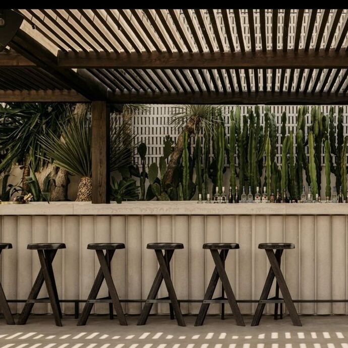 Cuisine d'été au style grec, épuré avec un grand comptoir en béton matrice et les bois clairs et foncés se mêlent dans une harmonie naturelle apportant une touche chic et élégante à l'ensemble.