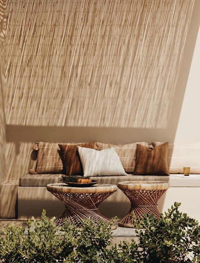 Petit salon de jardin ombragé par des canices offrant une atmosphère naturelle et décontractée, idéal pour les après midis d'été.