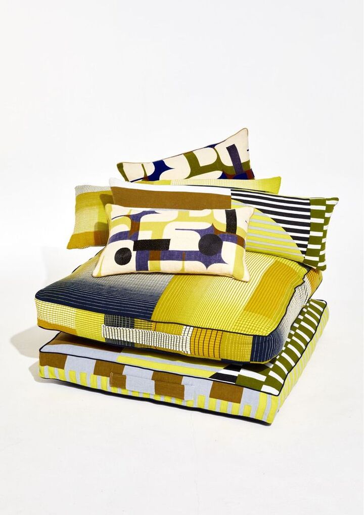 Coussin dans des couleurs de l'été 2025 avec beaucoup de motifs à rayures ou géométriques dans des tons jaunes.